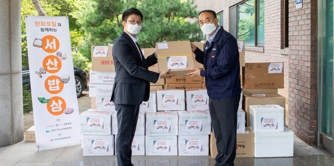 한화토탈이 신종코로나바이러스감염증의 여파로 어려움을 겪는 지역농가를 돕기 위해 서산밥상 데이를 진행했다고 밝혔다. 사진은 왼쪽부터 한화토탈 직원이 고객사 삼동산업을 방문해 김태규 삼동산업 이사에게 서산지역 특산물을 전달하는 모습. 사진ㅣ한화토탈
