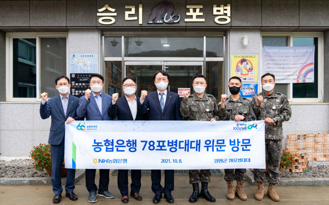 지난 8일 농협은행 권준학 은행장(사진 가운데)과 직원들이 경기도 양평에 위치한 78포병대대를 방문해 박후성 제11기동 사단장(사진 오른쪽에서 세 번째) 및 78포병대대 관계자들과 함께 기념촬영을 하고 있다. 사진 | NH농협은행)