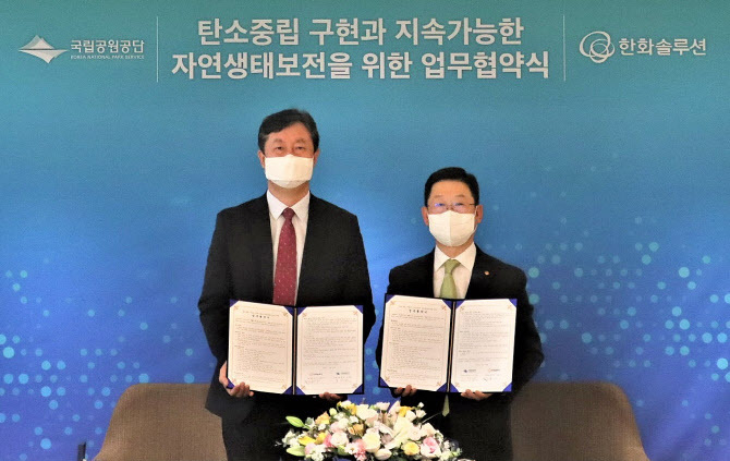한화솔루션과 국립공원공단이 공단 내 주요 시설에 친환경 에너지를 공급하는 방식으로 생물 다양성 보전에 나서기로 한 가운데, 지난 16일 서울 장교도 한화빌딩에서 이구영(오른쪽) 한화솔루션 대표가 송형근 국립공원공단 이사장과가 ‘탄소중립 구현과 지속 가능한 자연 생태 보전을 위한 업무협약’을 체결한 뒤, 기념촬영을 하고 있다. 사진 | 한화솔루션 