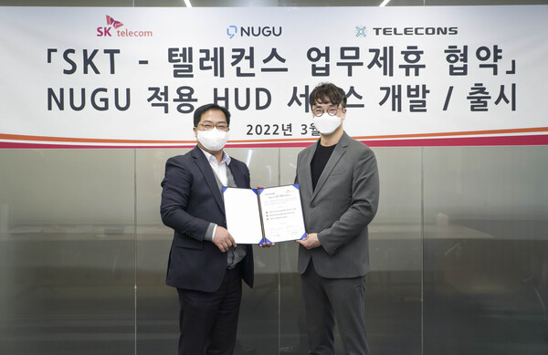 SK텔레콤이 텔레컨스와 차량용 Head Up Display와 연동하는 서비스에 ‘누구 소프트웨어 개발 킷’을 탑재해 안 운전을 돕는 서비스 개발 관련 사업협약을 체결한 가운데, 협약식에서 신상욱 SK텔레콤 AI 서비스 담당(오른쪽)과 박성민 텔레컨스 부사장이 기념촬영을 하고 있다. 사진 | SK텔레콤