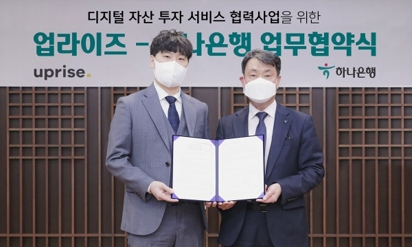 하나은행이 지난 19일 서울 중구 을지로 하나은행 본점에서 디지털자산 투자 서비스 기업 업라이즈와 전략적 업무 협약을 체결한 가운데, 성영수 하나은행 CIB그룹 부행장(오른쪽)과 이충엽 업라이즈 대표가 기념 촬영을 하고 있다. 사진 | 하나은행