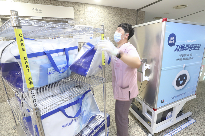 분당서울대병원 직원이 본관 3층 수술실 앞에 도착한 ‘자동이송 로봇’에서 환자 수술에 필요한 물품을 꺼내 수술실로 이동을 준비하고 있는 모습. 사진 | KT