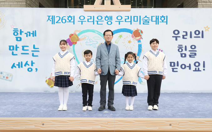 우리은행 조병규 은행장이 지난 14일 용산 전쟁기념관에서 열린 ‘제26회 우리은행 우리미술대회’ 축하공연 및 그림주제 발표에 함께 참여한 우리다문화어린이합창단 단원들과 기념사진을 촬영하고 있다. 사진 | 우리은행