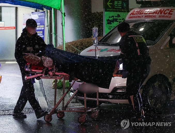정부의 의대 증원에 반대하며 사직서를 제출한 전공의가 주요 100개 수련병원에서 9천명을 넘어섰다. 이들 병원을 이탈한 전공의의 수도 8천명을 넘어섰다. 수도권을 비롯한 중부지역에 대설주의보가 내린 21일 밤 서울 시내 한 대형병원 응급실에서 구급대원들이 환자를 이송하고 있다. 사진 ㅣ 연합뉴스