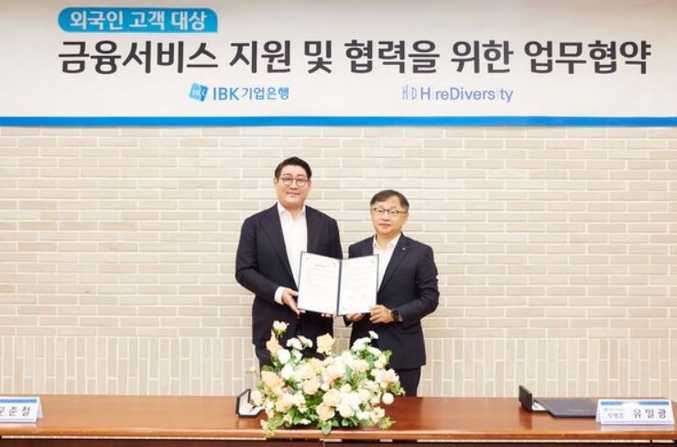 지난 14일 서울 중구 을지로 기업은행 본점에서 열린 업무협약식에서 유일광 IBK기업은행 개인고객그룹 부행장(오른쪽)과 문준철 하이어다이버시티 이사가 기념촬영을 하고 있다. 사진 | IBK기업은행