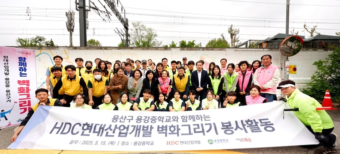 HDC현대산업개발은 15일 도시정비부문 임직원과 용산구 주민, 용강중학교 학생 등 40여 명과 함께 서울시 용산구 용강중학교 일대 담장 벽화그리기 봉사활동을 진행했다. (사진 앞에서 두 번째 줄 오른쪽 다섯 번째부터 권충환 용강중학교장, 강경민 HDC현대산업개발 도시정비부문장, 박희영 용산구청장) 사진 | HDC현대산업개발