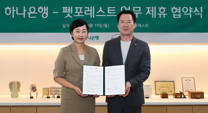 하나은행은 지난 19일 반려동물 장례서비스 제공 업체인 (주)펫포레스트와 수신 VIP 손님 지원을 위한 업무협약을 체결했다. 이날 협약식에 참석한 이은정 하나은행 하나더넥스트본부장(사진 왼쪽)이 이상흥 펫포레스트 대표(사진 오른쪽)와 함께 협약서를 들고 기념 촬영을 하고 있다. 사진 | 하나은행