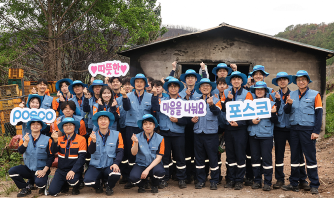 지난달 22일, 포스코 이희근 사장(둘째줄 왼쪽에서 네 번째)을 포함한 임직원들이 영덕 산불 피해 농가 지원활동을 진행한 뒤 기념촬영을 하고 있다. 사진 | 포스코