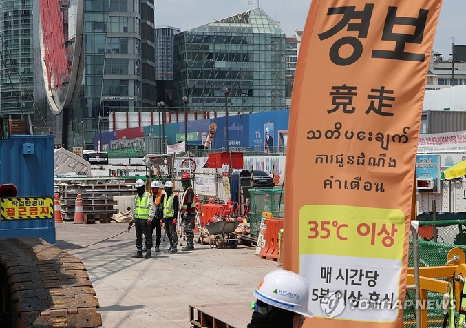 14일부터 '폭염 시 2시간 일하면 20분 이상 휴식' 제도가 주어진다. 산업안전보건규칙 개정안 규제개혁위 규제 심사 3수 끝에 이 법안이 통과됐다. 8일 폭염 경보가 발효 중인 서울 강남구 한 공사현장에 '체감온도 경보' 안내문이 설치돼 있다. 사진 ㅣ 연합뉴스