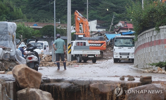 21일 행정안전부의 국민안전관리 일일상황보고에 따르면 20일 오후 9시 기준 전국에 내린 극한호우로 사망자가 18명, 실종자가 9명 발생했다. 20일 오후 경남 산청군 산청읍 외정마을에서 주민이 전날 집중호우와 산사태로 파괴된 마을을 보고 있다. 사진 ㅣ 연합뉴스