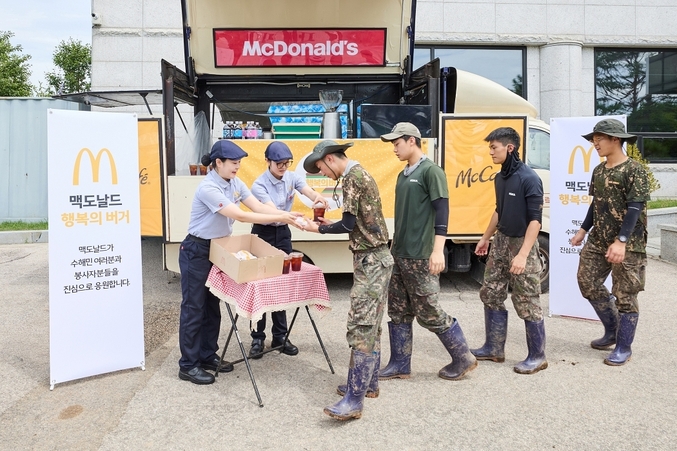 가평 지역 수해 복구에 참여한 군 장병들이 맥카페 음료트럭 앞에서 버거와 음료를 수령하고 있다. 사진 | 한국맥도날드