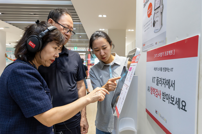 KT플라자에 방문한 고객이 KT 직원으로부터 AI 청력검사 키오스크의 사용법에 대한 설명을 듣고 있다. 사진 | KT
