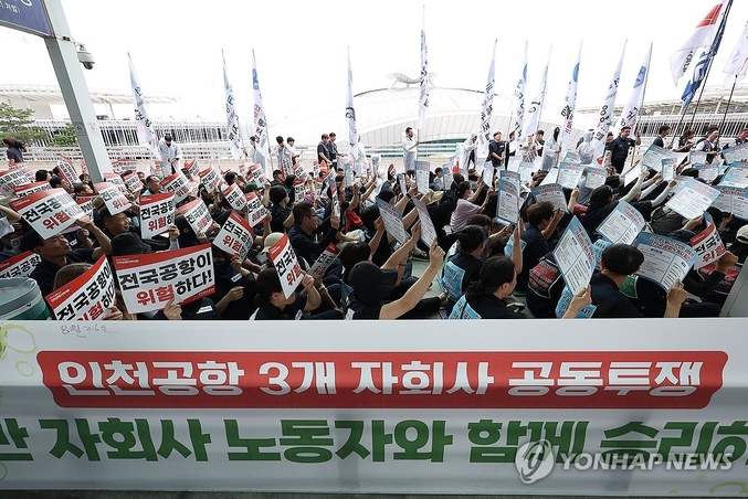 인천공항 제2여객터미널 앞 전국공항노동자연대 총파업 대회. 인천국제공항 노동자가 가입한 민주노총 공공운수노조 인천공항지역지부와 나머지 14개 공항 노동자가 가입한 전국공항노동조합으로 구성된 전국공항노동자연대가 지난 19일 인천 영종도 인천국제공항 제2여객터미널에서 연 총파업 대회에서 참가자들이 손팻말을 들고 구호를 외치고 있다. 전국공항노동자연대는 이날 경고 파업을 진행한 후 추석 연휴 전 무기한 총파업을 진행할 것이라고 예고했다. 사진 ㅣ 연합뉴스