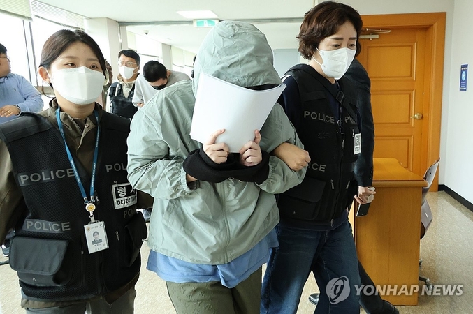 얼굴 가리는 캄보디아 송환 피의자. 20일 오후 충남경찰청에서 사기 혐의로 수사받는 캄보디아 송환 피의자들이 충남 홍성 대전지법 홍성지원에 구속 전 피의자심문(영장실질심사)을 받기 위해 출석하고 있다. 사진 ㅣ 연합뉴스